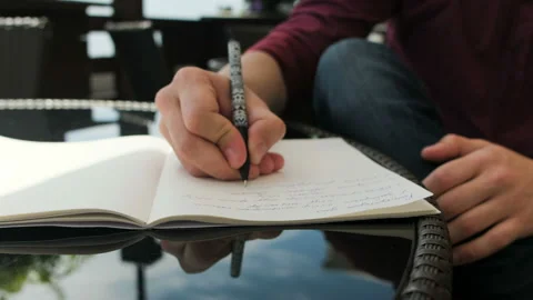 The guy in the summer cafe makes a notepad Stock Footage 96388782