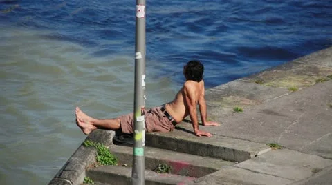 Guy sunbathing  man next to a river Stock Footage 22241427