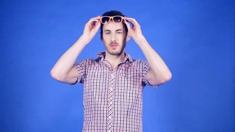 The guy in sunglasses on blue background Stock Footage 74953974