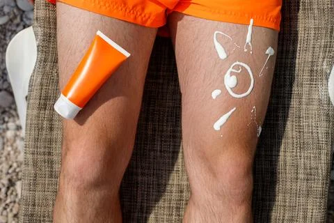 Guy with sunscreen on his leg Stock-Fotos