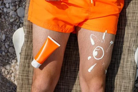 Guy with sunscreen on his leg Stock Photos