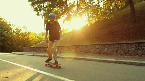 The guy at sunset does a trick on a skateboard, a longboard. Stock Footage 136852909