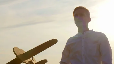 The guy at sunset dreams and plays with the airplane Stock-Footage 73440661