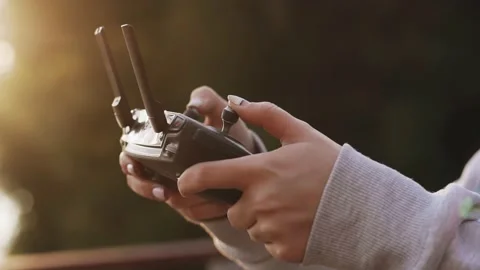 A guy at sunset holds a remote control of a drone in his hands Stock Footage 157430779