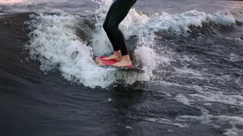A guy on a surfboardrolls on the waves of the city channel in slow motion Stock Footage 205610703