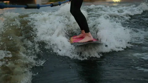 A guy on a surfboardrolls on the waves of the city channel in slow motion Stock Footage 205610857