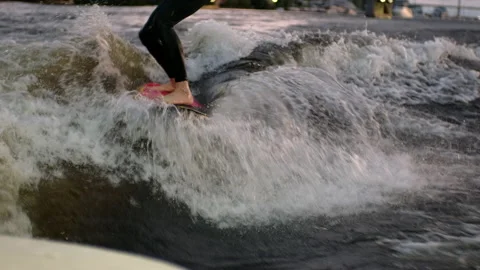 A guy on a surfboardrolls on the waves of the city channel in slow motion Stock Footage 205610989