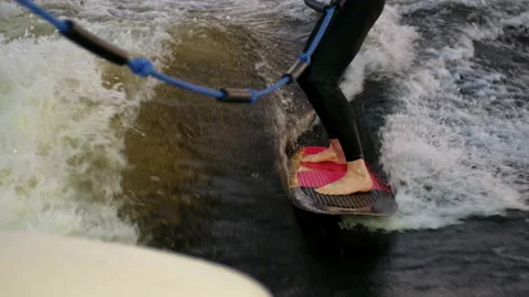A guy on a surfboardrolls on the waves of the city channel. Stock Footage 205611196