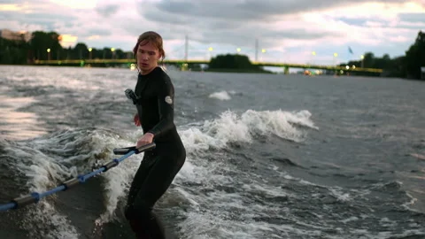 A guy on a surfboardrolls on the waves of the city channel in slow motion Stock Footage 205611508