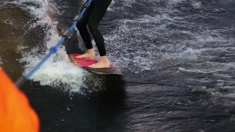 A guy on a surfboardrolls on the waves of the city channel in slow motion Stock Footage 205611615