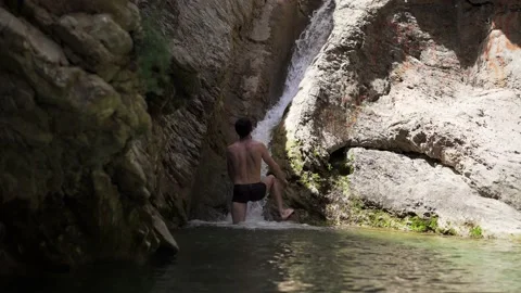 The guy swims under the waterfall in the Old Bar Montenegro Video stock 196125480