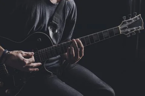 Guy in a T-shirt plays an electric guitar Stock Photos