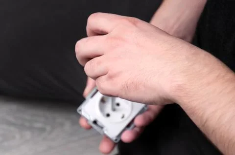 The guy takes apart the socket before installing it. Repair in the house. Rep Stock Photos