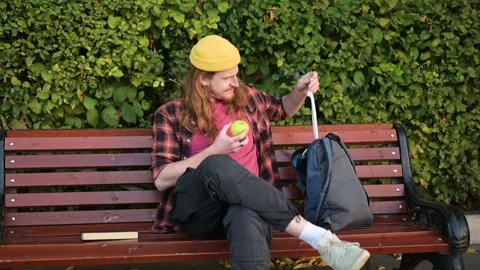 Guy takes an apple out of his backpack and begins to rub it with wet wipes 库存影片 250642599