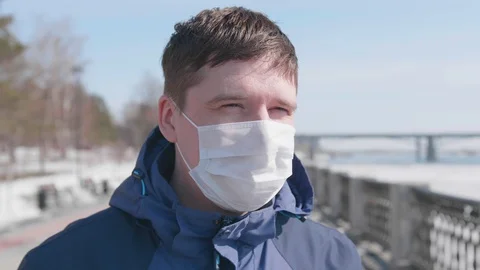 The guy takes off his protective mask on the street. Prevention and protection Video stock 129960189