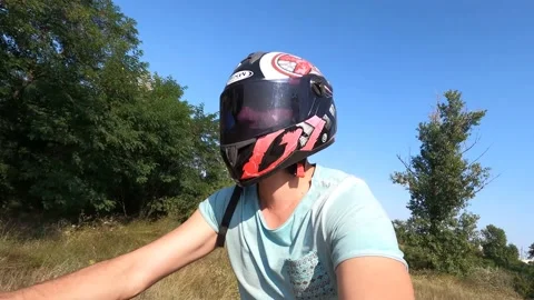 The guy takes a selfie as he rides an ATV in a helmet in a pine forest. Video stock 159853010