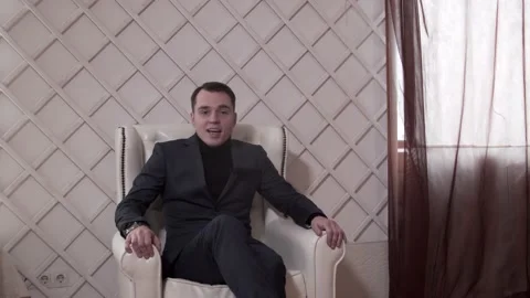 The guy is talking to the camera. In a classic suit. The guy is sitting Stock Footage 130222763