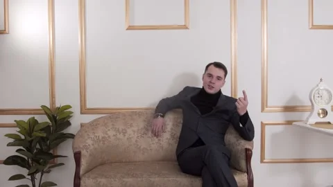 The guy is talking to the camera. In a classic suit. The guy is sitting Stock Footage 130222905