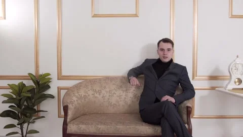The guy is talking to the camera. In a classic suit. The guy is sitting Stock Footage 130223085