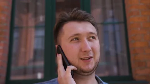 The guy is talking on the phone against the background of the office window Stock Footage 139011072