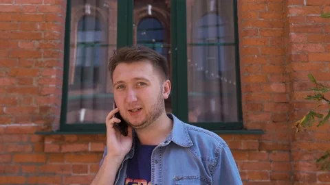 The guy is talking on the phone against the background of the office window Stock Footage 139011112