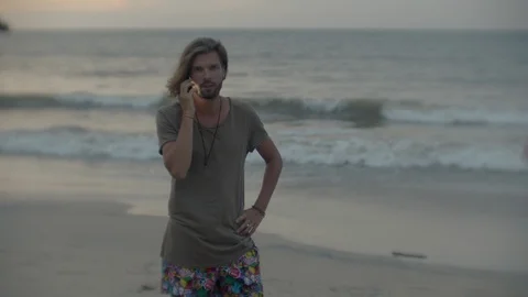 Guy talking on the phone on the beach Bali Stock Footage 105933927