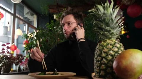 Guy talking on the phone at the dinner table Vidéo 170559149