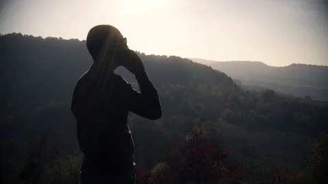 The guy talking on the phone on the mountain Stock Footage 97277886