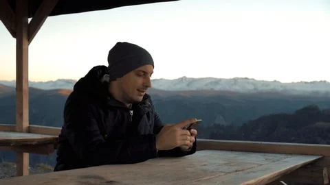 The guy talking on the phone in the Mountain Ranges Stock Footage 98451044