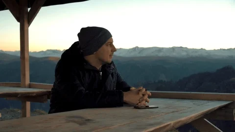 The guy talking on the phone in the mountains Stock Footage 98450992