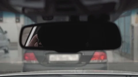 Guy talking on the phone in the reflection of the car mirror Stock Footage 102111828