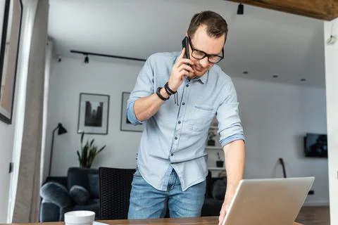 A guy is talking on phone, using laptop Stock Photos