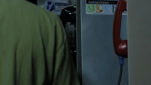 Guy talking on a public telephone Stock Footage 98760337