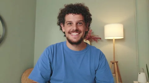 Guy talking on video call using laptop, waving his hand in greeting Stock Footage 250841453