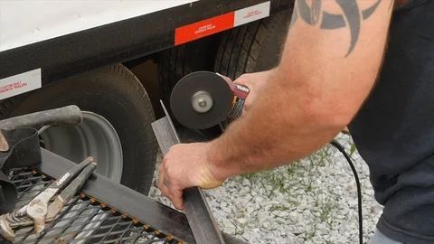 Guy with Tattoo Grinding Angle Iron Outdoors Stock Footage 104890641