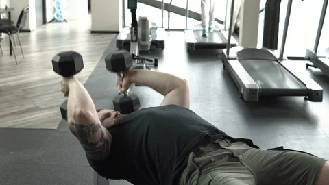 Guy with a tattoo trains with a dumbbell close-up 4k. Stock Footage 85597211