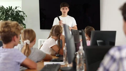 Guy teacher teaches group of students in computer class Stock Footage 277179650