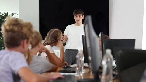 Guy teacher teaches group of students in computer class Stock Footage 307063967