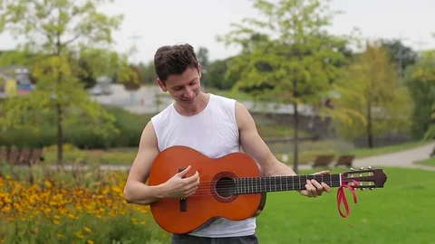 Guy throwing the guitar up. Then catching her and playing Stock Footage 79734912