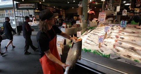 A guy throwing salmon fish in Seattle Pike Place Market Stock Footage