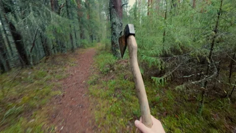 The guy throws an axe at a tree trunk several times, but misses. Stock-Footage 320945064