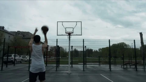 Guy throws a basketball into the ring for outdoor area Stock Footage 76067090