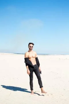 A guy throws sand on the sand on a hot summer day Stock Photos