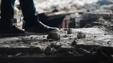 The guy throws stones on the floor of an old abandoned house with his feet Stock Footage 131877582