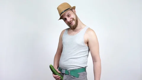 Guy touches a large cucumber which wears away out of his pants. Stock Footage 129401659