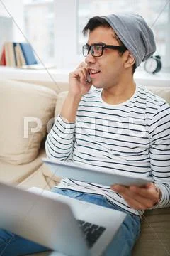 Guy with touchpad, laptop and cellphone calling someone Stock Photos
