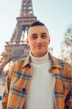 Guy tourist on the background of the Eiffel Tower posing. Male tourist laughs Stock Photos