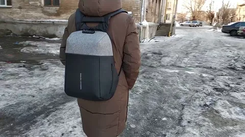 A guy in town with a backpack in winter Stock Footage 106346637
