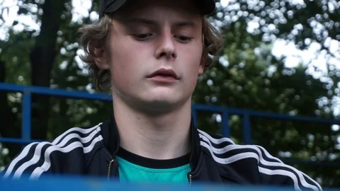 Guy in the tracksuit sits on the tribune Video stock 103649527