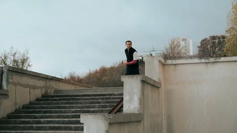 The guy is training parkour. Jumps on the railing on a cold autumn day. Does a Video stock 120240636
